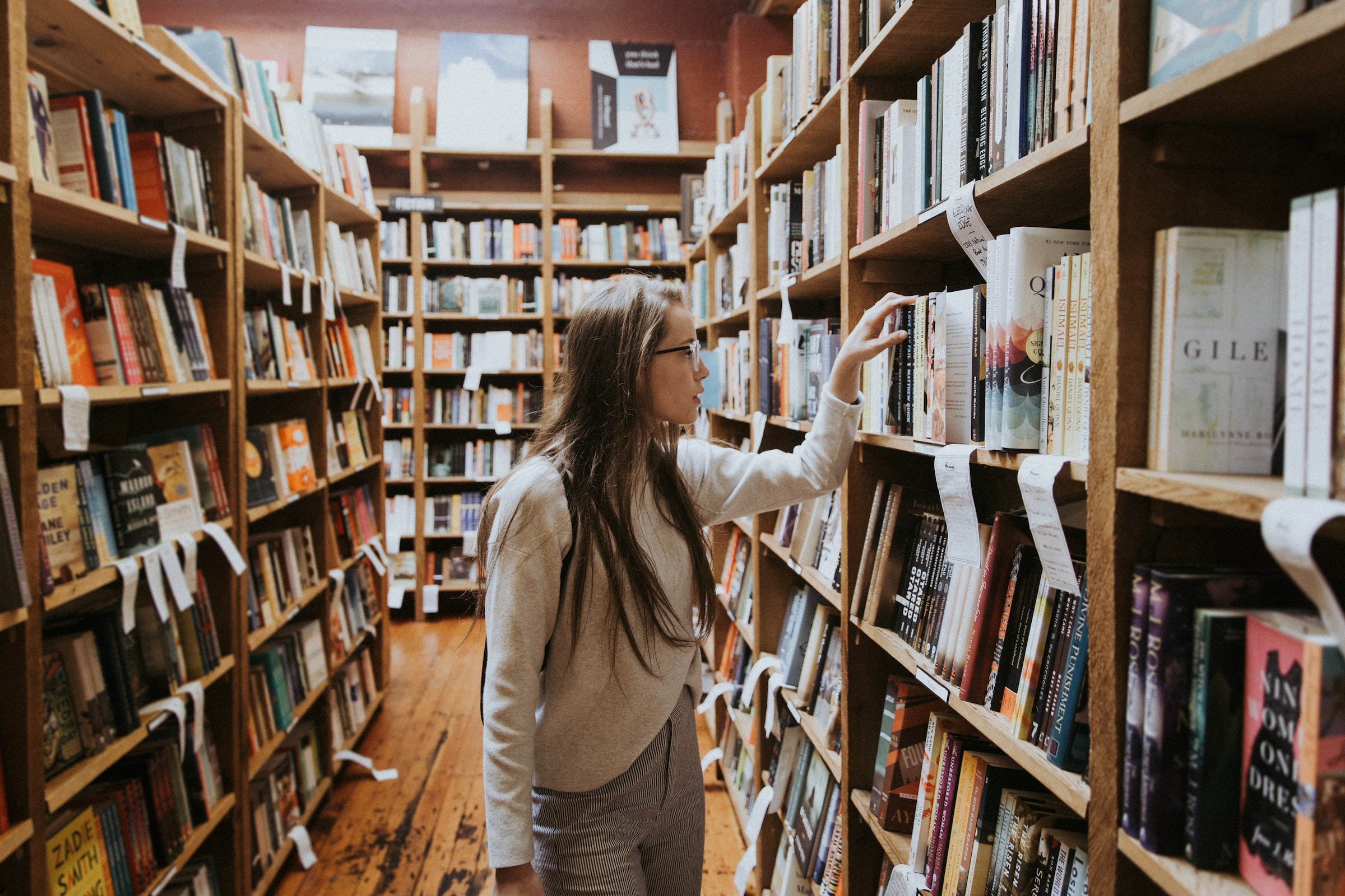 Young woman looking for a book in a library
